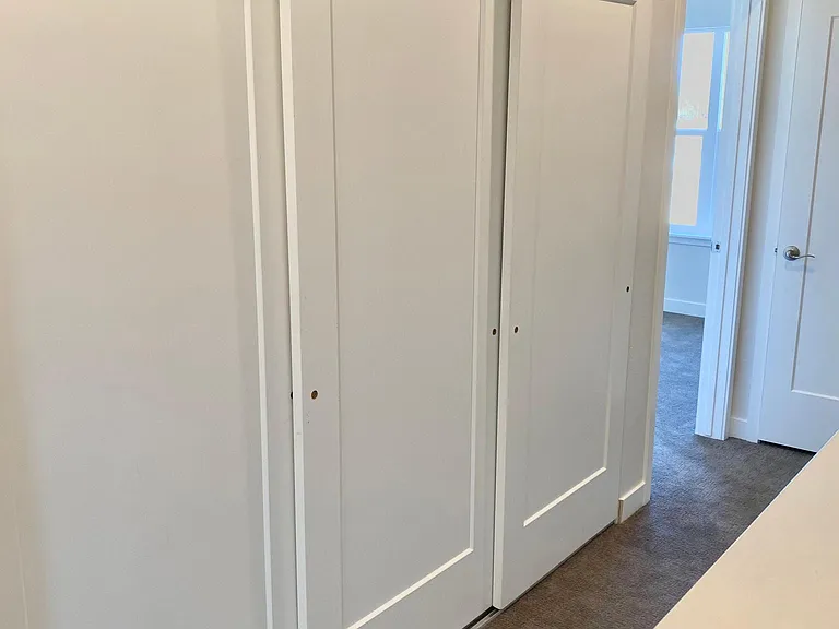 Stackable Washer/Dryer, tankless water heater and HVAC closet at top of stairs.