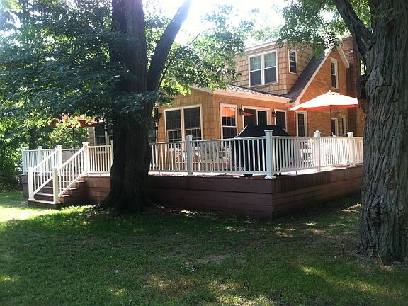 Back of home with a huge wrap around deck and another smaller fire pit in the back yard