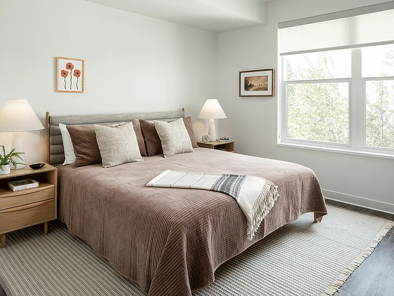Spacious apartment bedroom with plush carpet flooring.