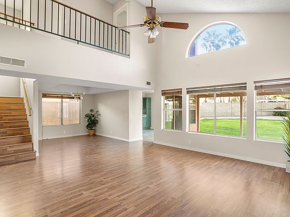 Dramatic living room with vaulted ceilings and views of the grassy backyard