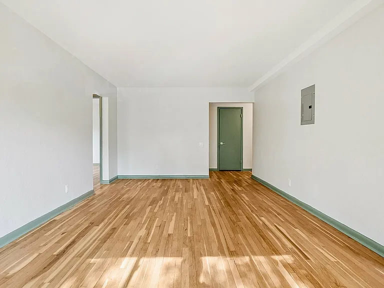 Bright and spacious room with elegant hardwood floors and clean white walls, offering a canvas for your dream living space.