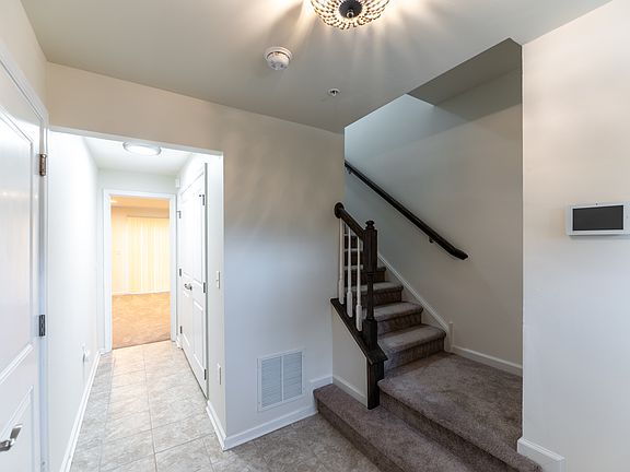 Entryway with view to stairs and first floor bedroom and bathroom
