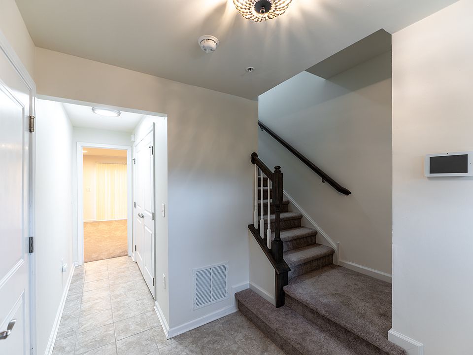 Entryway with view to stairs and first floor bedroom and bathroom