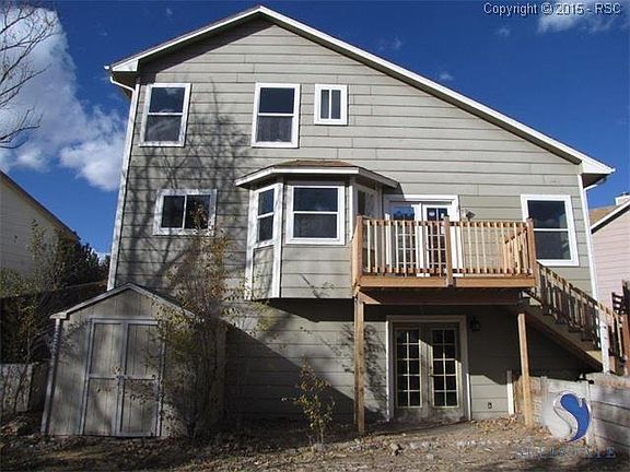 Rear view of the home, new deck, and handy garden/storage shed.