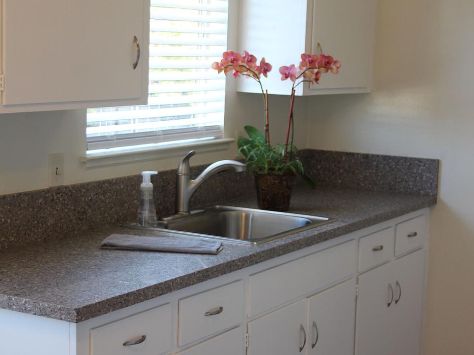 Beautifully updated kitchen with quartz countertops, new stainless steel sink and sprayer faucet, garbage disposal, freshly painted cabinets, new refrigerator, electric stove and oven