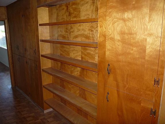 Many paneled walls, with built in book/DVD/VHS cases, tons and tons of storage