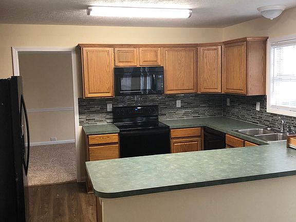 large kitchen with new appliances and tile back splash