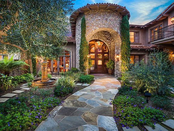 Elaborate privacy doors open to the lush garden entry courtyard with fountain leading to the magnificent front door.