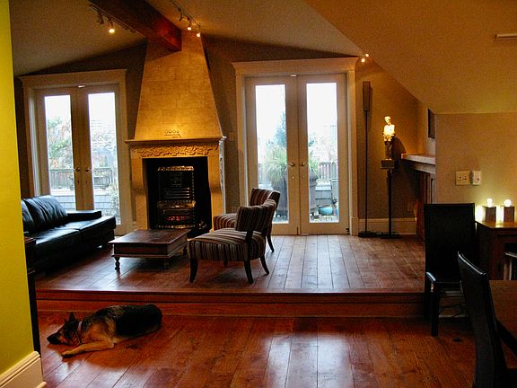 top floor loft living area with 2 sets of double doors to upper deck