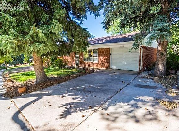 Single car attached garage with additional driveway space and backyard access on the side