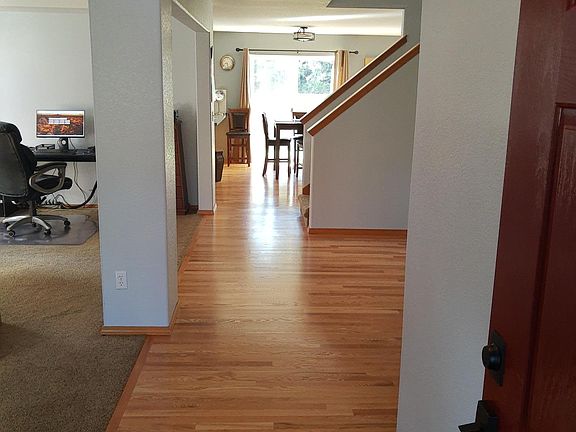 Front door entrance; real hardwood - only clean with water & vinegar; living room to left with high vaulted ceiling; half bath, laundry room & garage exit to the right.