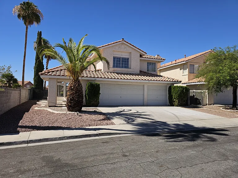 A spacious home with a three-car garage and desert-friendly landscaping, offering curb appeal and ea