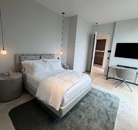 Photo 1 of 4 - Inverness Dr - Sarasota, FL Well-appointed bedroom with a full bed, bedside storage, pendant lighting, and a TV setup, plus ensuite bath access. - Inverness Dr