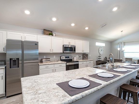 Open kitchen with Counter-height Island - New home for sale in Lake Alfred, FL. Photo showcases the