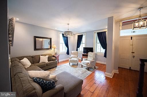 Roomy living room with wide plank floors and front entrance