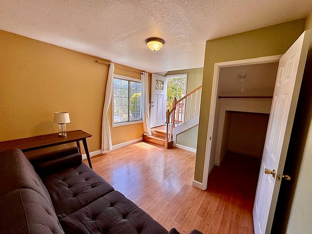 LiLiving room with a window overlooking the front lawn, storage/closet.