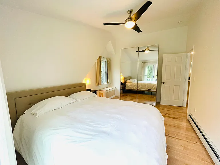 Bedroom: Queen sized bed with linens, mirrored closet, sliding door to deck
