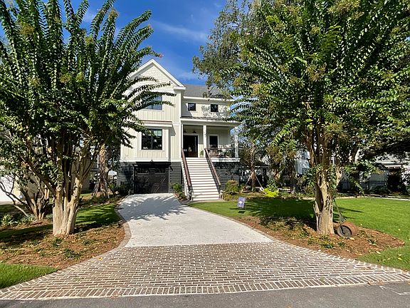 Home exterior with 2 driveways, garage for 2 cars, parking pad for another car beyond garage