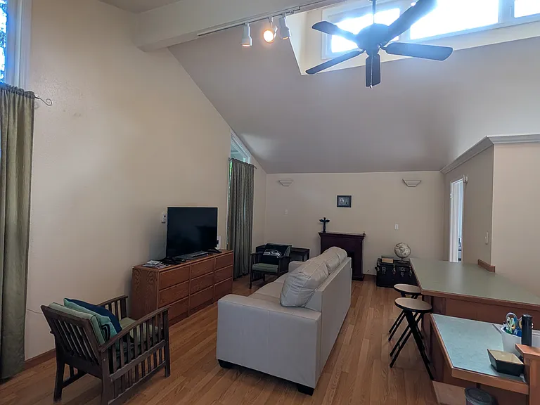 View of living room with vaulted ceilings and clerestory windows for beautiful natural light and eat in kitchen bar