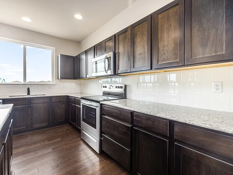 Beautiful Open Kitchen with Expresso Cabinets, Granite Countertops, Stainless Steel Appliances and LVP Flooring