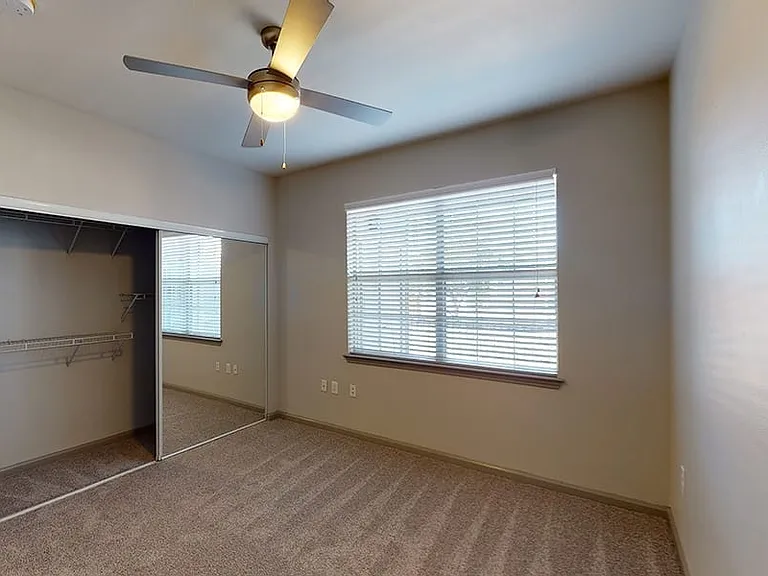 Spacious apartment bedroom with plush carpet flooring