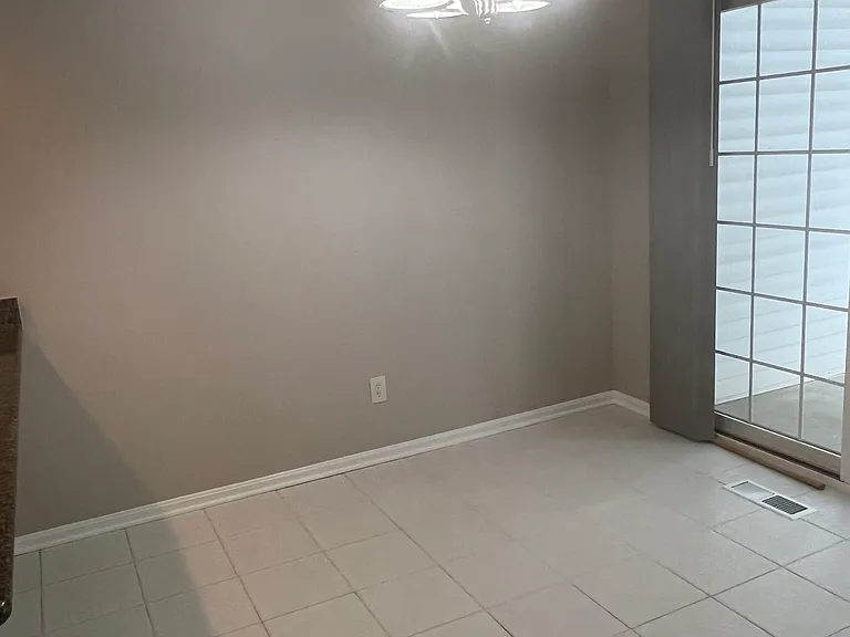 Dining area with sliding glass door opening to private patio and backyard.