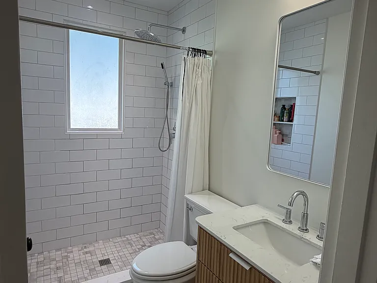 Newly renovated bath. Features walk-in shower, rain, and hand shower heads. Awesome contemporary lighting.