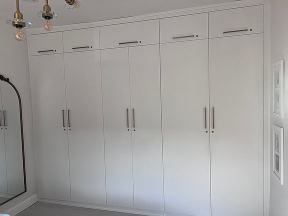 Exceptional storage for a home of this size: custom floor-to-ceiling cabinetry keeps the bedroom streamlined, organized, and beautifully uncluttered.