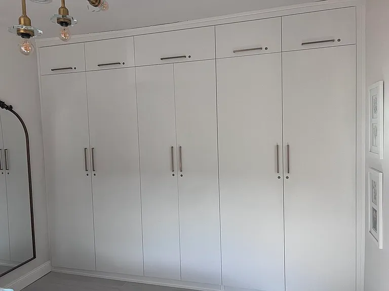 Exceptional storage for a home of this size: custom floor-to-ceiling cabinetry keeps the bedroom streamlined, organized, and beautifully uncluttered.