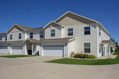 The exterior of a comfortable Osgood townhome in Fargo ND, with a garage, front door, and front yard - Osgood Townhomes