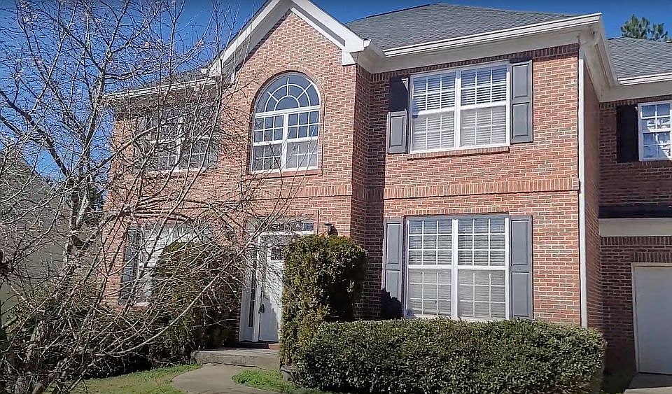 Facade of an unfinished two-story house with no red brick windows