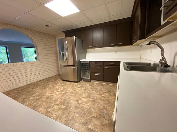Kitchen with full fridge, freezer, and small wine cooler under the counter.