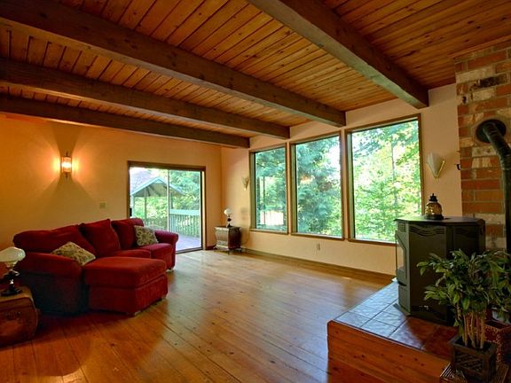 Cozy up by the stove while enjoying a peaceful greenbelt out your huge windows or step out onto the side deck and relax in the gazebo.  Look at the beautiful wood floors and ceiling.  Quality abounds.
