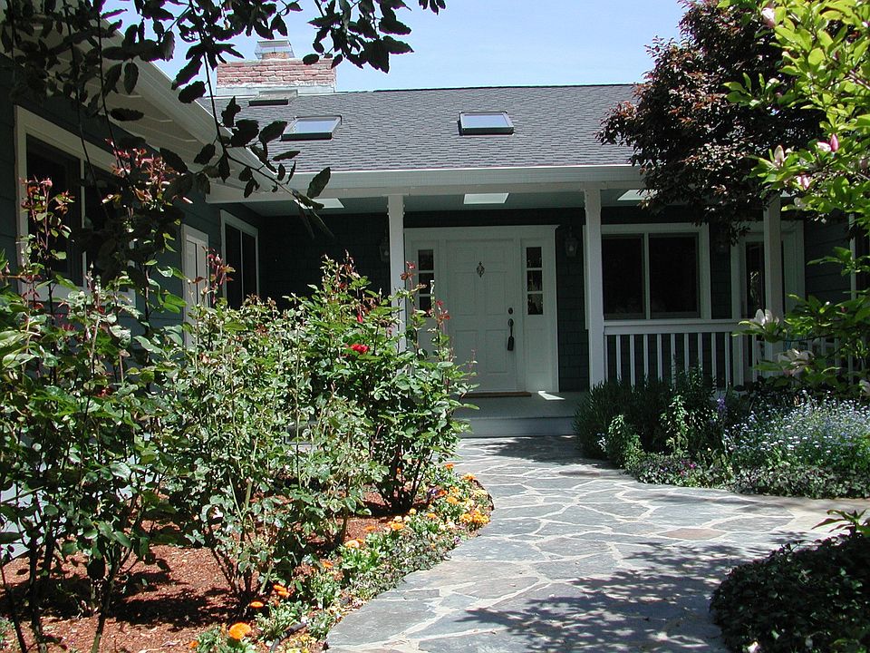 Gorgeous front garden filled with flowers and charming pond.