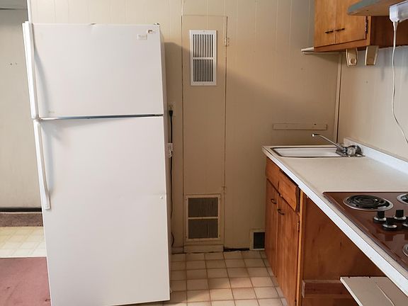 Kitchen showing refrigerator and single sink.