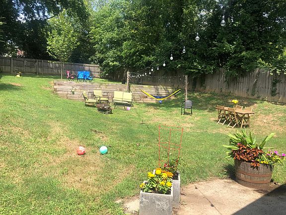 large fenced in backyard with hammock posts