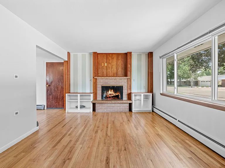 Charming details shine throughout, with neutral paint, warm wood elements, and custom built-ins framing the cozy wood-burning fireplace.