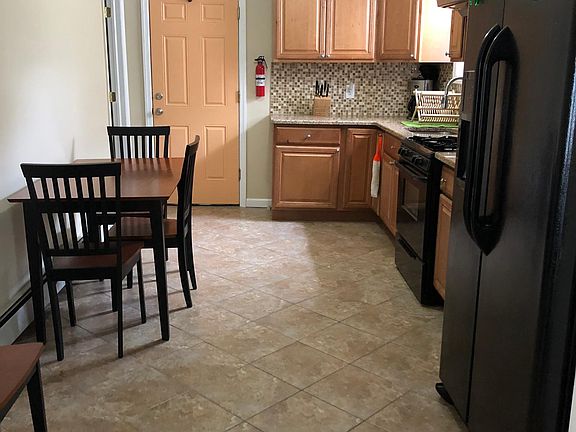 Eat-in kitchen with gas stove, microwave, and side-by-side refrigerator.