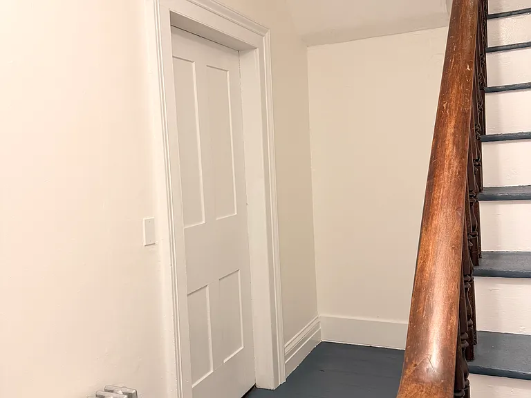 Entryway with space for coats, shoe racks, or storage.