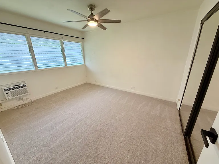 Second bedroom with window ac unit and brand new carpet