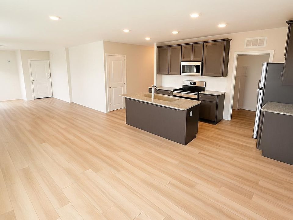 Center Island kitchen with stainless steel appliances. Wide plank oak flooring throughout the apartment.