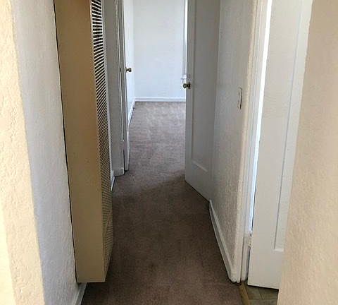 Hallway with wall heater.