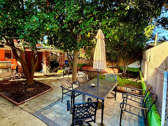 Private backyard with mature citrus trees, shaded patio, and outdoor seating _ perfect for relaxing or entertaining.