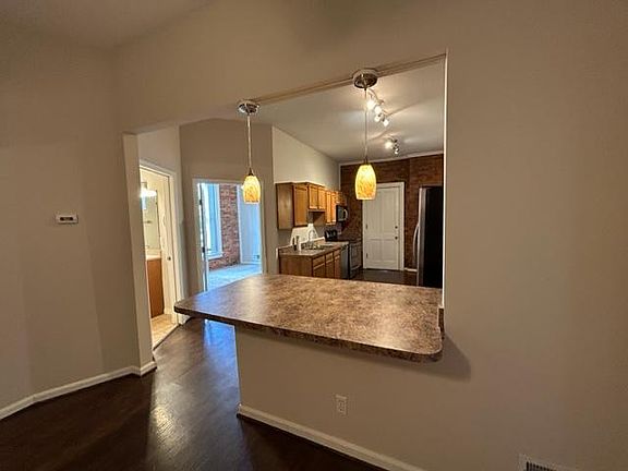 Kitchen, counter-height bar/peninsula, open to great room. Bathroom and Bedroom #2 are to the left.