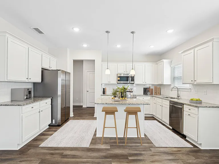 View of the kitchen and entry hallway. Offering bar seating, plenty of cabinet space and granite countertops.