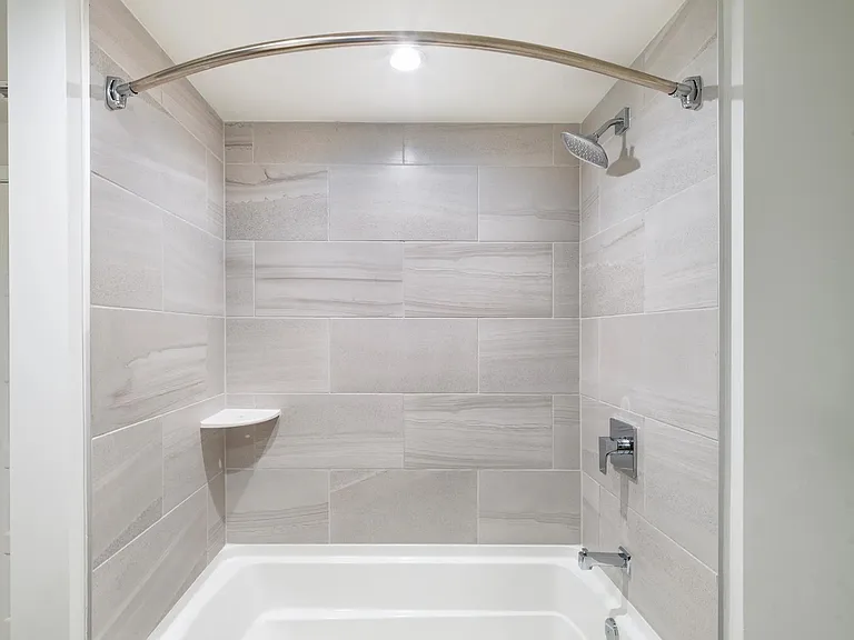 Sleek tile surrounds and polished fixtures bring a refined touch to bathrooms at Modera Aventura.