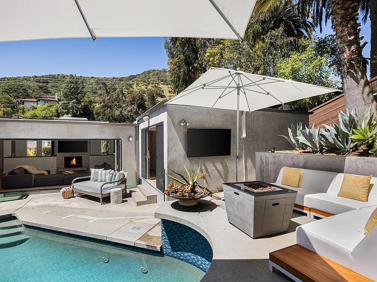 Discover the allure of the poolside fire pit, surrounded by plush seating.