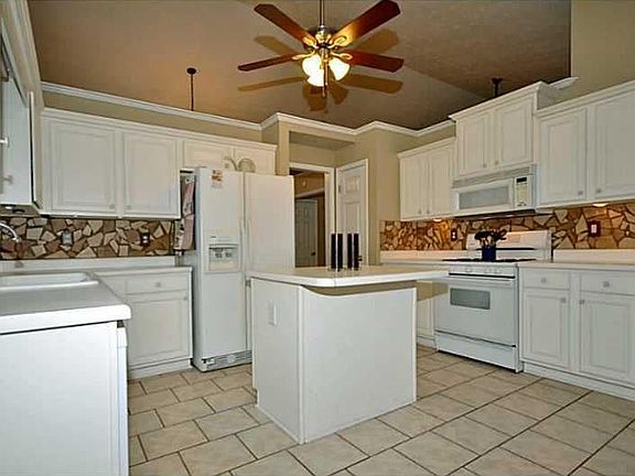 Tiled floor in kitchen with white cabinets