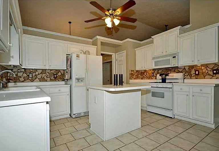 Tiled floor in kitchen with white cabinets