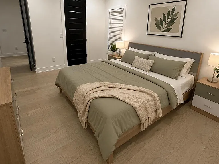 Well-appointed bedroom with a queen bed, matching nightstands, dresser storage, and a window with blinds.